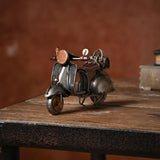 Retro Scooter Metal Ornament Figurine in bronze and copper, featuring curved bodywork, round headlamp, twin mirrors and copper seat, displayed on a wooden table.
