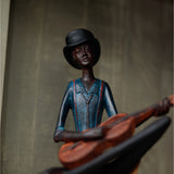Hill Interiors Sitting Musician Figurine in brown resin, wearing a black bowler hat and blue jacket, holding a stringed instrument against a neutral backdrop.
