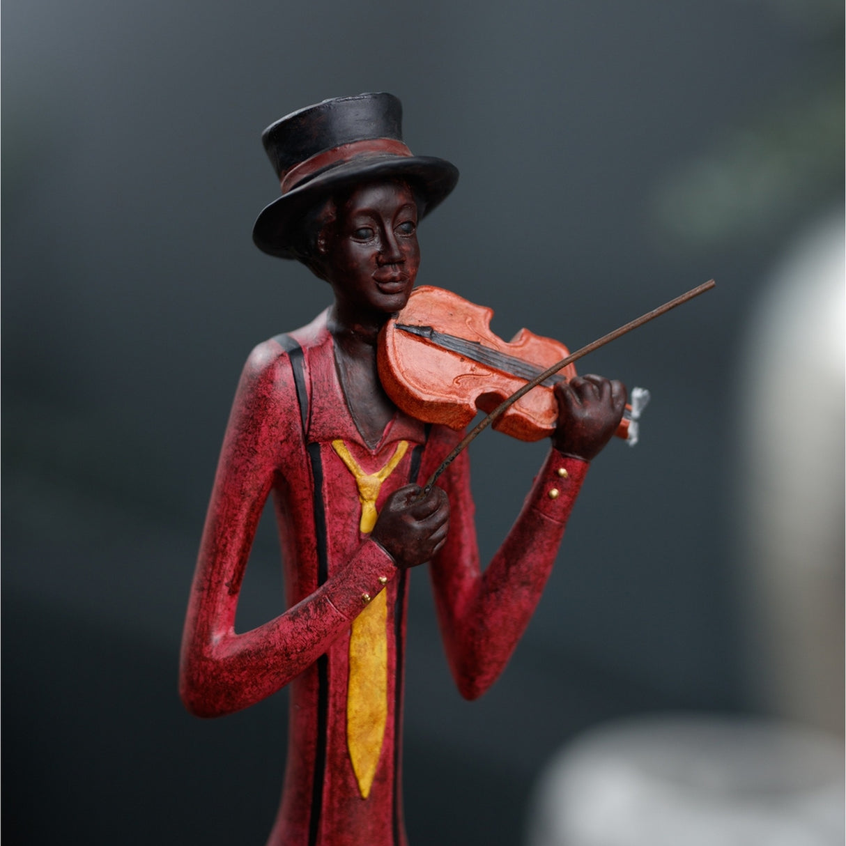 Hill Interiors Standing Violinist Figurine in resin, shown mid-performance in a red coat, yellow waistcoat and black top hat, holding a violin and bow.
