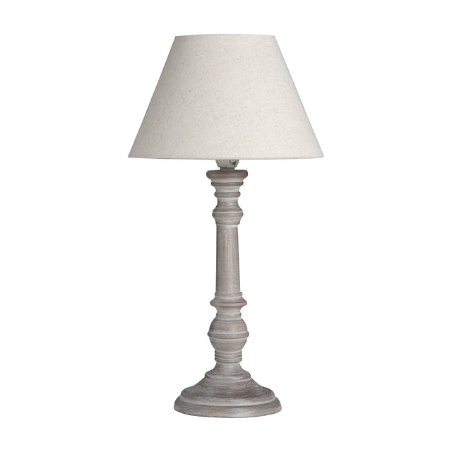 Hill Interiors wooden table lamp with turned column base in a washed beige finish and tapered neutral linen shade, shown on a plain white background.