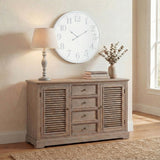 Hill Interiors Wooden Table Lamp in beige with a turned solid wood base and tapered linen shade, styled on a wooden sideboard beside a large wall clock.