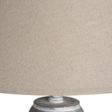 Close-up of the beige fabric drum shade and turned wooden base on the Hill Interiors Wooden Floor Lamp, showing woven texture and soft wood grain.