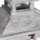 Close-up of Hill Interiors grey wooden lantern showing the pagoda-style tiered roof, weathered painted finish, and small brass latch on the hinged door.