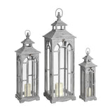 Hill Interiors Set of Three Wooden Archway Lanterns in grey, graduated sizes with arched window panels, pillar candles inside, on a white background.