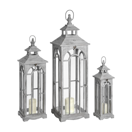 Hill Interiors Set of Three Wooden Archway Lanterns in grey, graduated sizes with arched window panels, pillar candles inside, on a white background.
