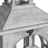 Close-up of the pitched roof and brass latch on a Hill Interiors grey wooden archway lantern, showing the weathered finish and arched opening below.