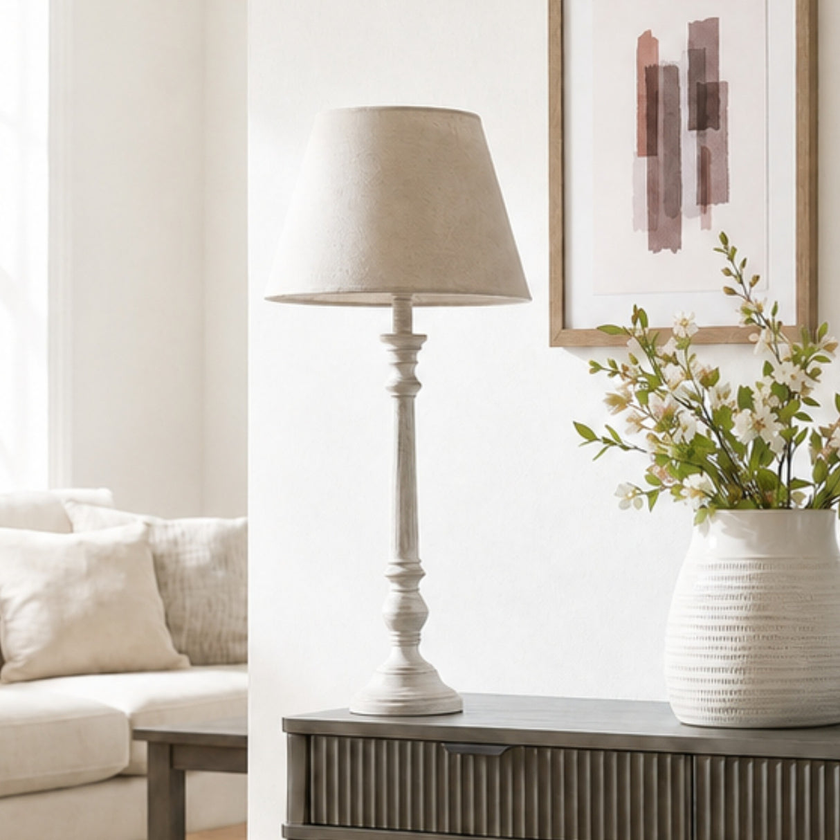Hill Interiors Wooden Table Lamp in grey with a turned timber base and tapered shade, styled on a console beside framed art and a floral vase.
