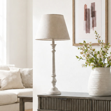 Hill Interiors Wooden Table Lamp in grey with a turned timber base and tapered shade, styled on a console beside framed art and a floral vase.