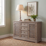 Hill Interiors Wooden Table Lamp in grey with turned timber base and tapered cream shade, lit on a wooden sideboard beside books and a framed botanical print.