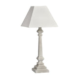Hill Interiors Wooden Table Lamp in white with a tapered turned column base, stepped square foot and tapered square fabric shade, on a plain background.