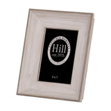 Hill Interiors white washed solid wood photo frame with visible grain and 5x7 aperture, shown upright at an angle on a plain white background.