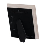 Rear view of Hill Interiors white washed wood photo frame showing black backing, hanging fittings and fold-out stand against a plain white background.
