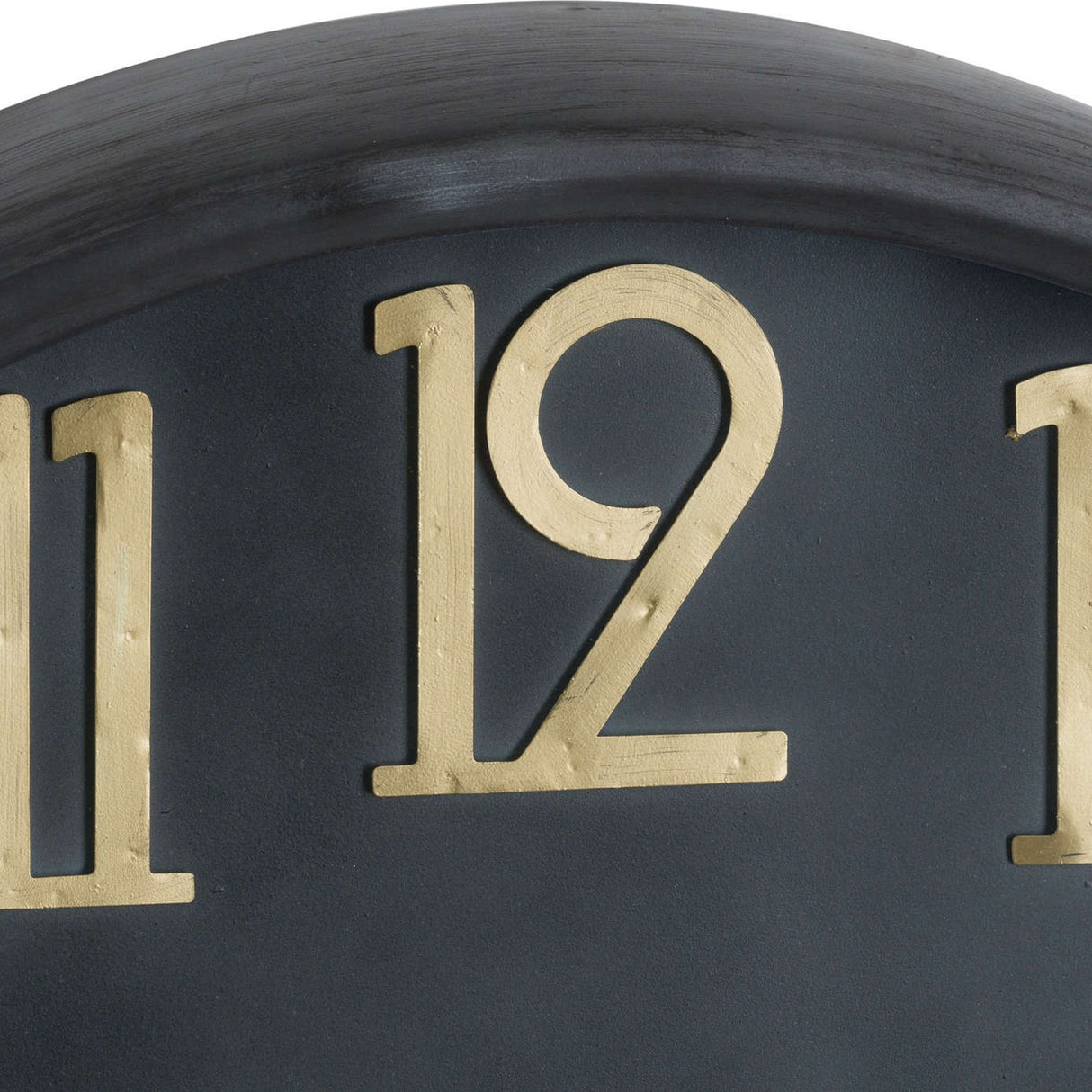 Close-up of the Hill Interiors Large Brass and Black Round Wall Clock showing brass numerals 11 and 12 on the black dial beneath the curved brass frame.
