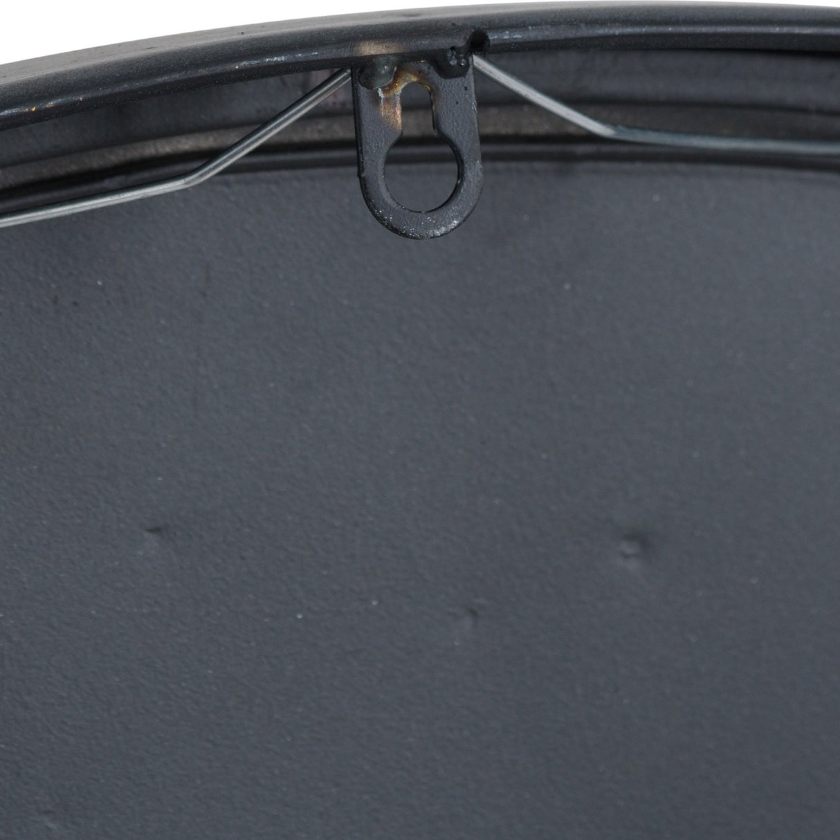 Close-up of the Hill Interiors Large Brass and Black Round Wall Clock showing the rear fixing loop, black backing and metal rim detail.