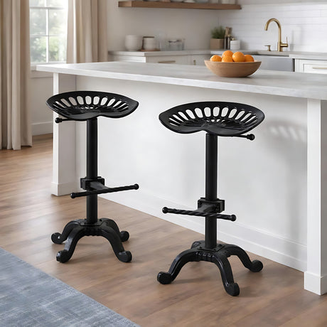 Pair of Hill Interiors Adjustable Metal Tractor Seat Stools in black, set beside a white kitchen island with a bowl of oranges on the worktop.