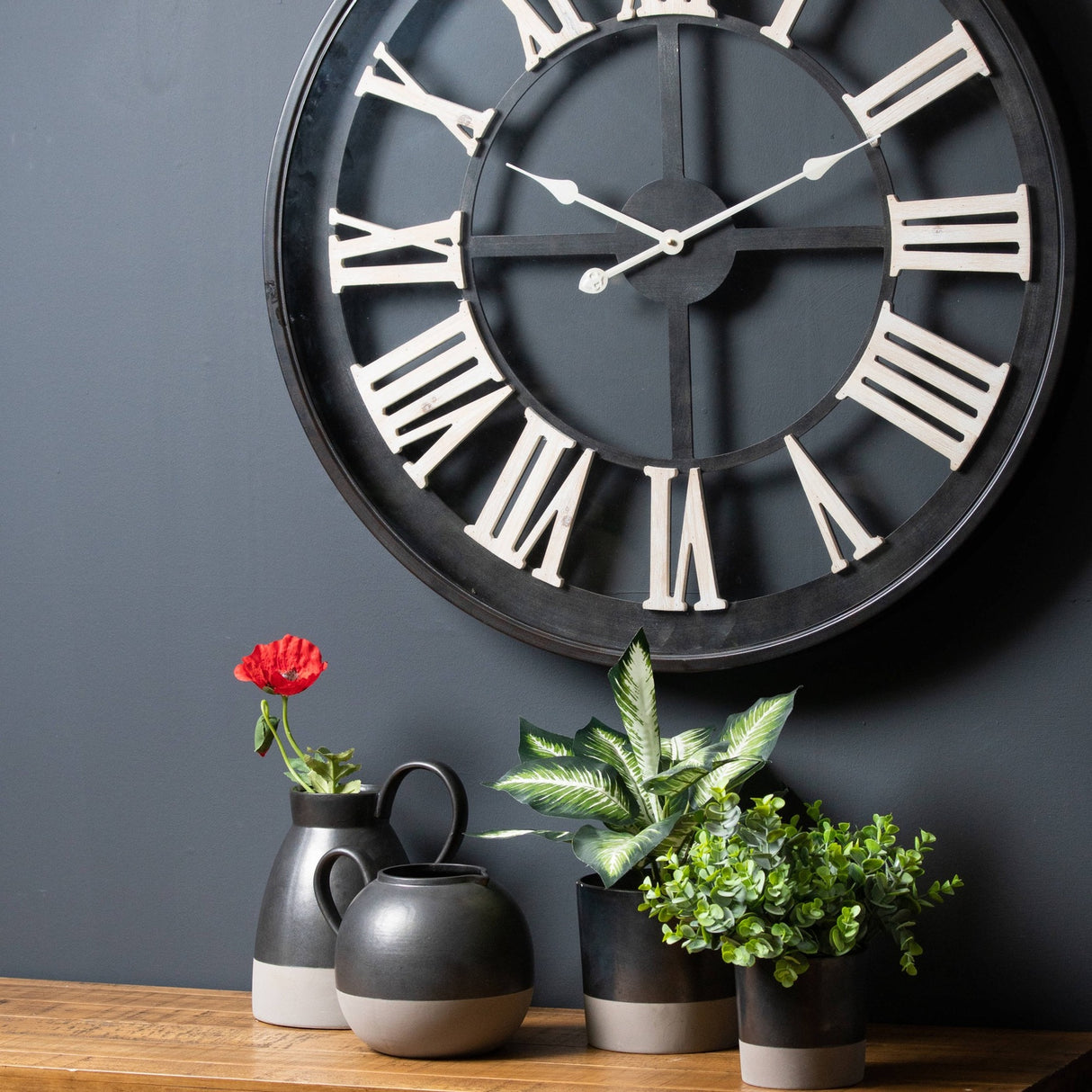 Hill Interiors Metallic Ceramic Serving Tray in grey styled with pitcher, round vase and potted greenery beneath a large Roman numeral wall clock.