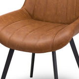 Close-up of the Hill Interiors Draxinby faux-leather dining chair in tan brown, showing channel-stitched seat and back over slim black metal legs.