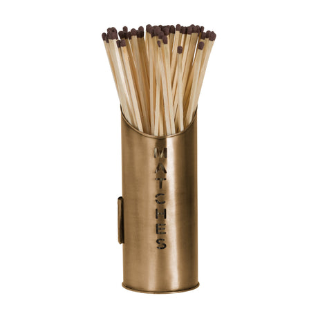 Hill Interiors bronze finish metal matchstick holder with cut-out MATCHES lettering, filled with long wooden matches with dark tips, on a white background.