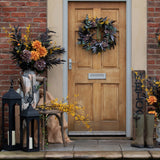 Autumn front porch styled with Hill Interiors floral arrangements, black lanterns, welcome sign, and wellies beside a wooden door with a seasonal wreath.