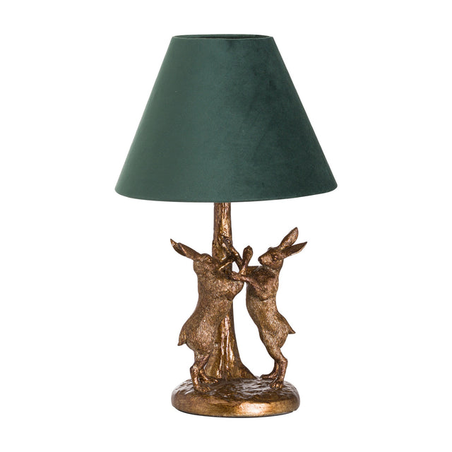 Hill Interiors Antique Gold Hares table lamp with two sculpted resin hares on a round base and a green velvet cone shade, on white.