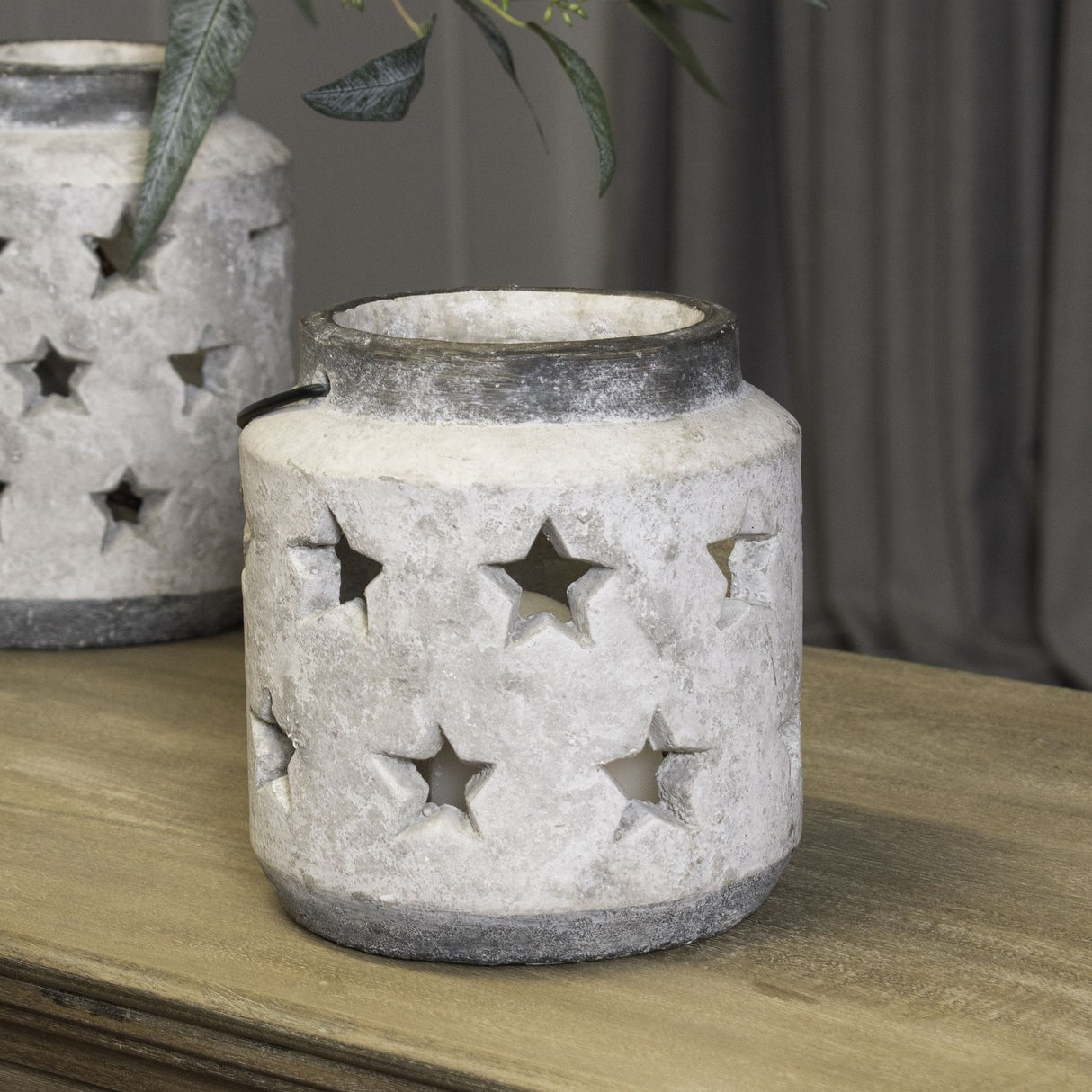Hill Interiors Stone Star Lantern ceramic candle holder in beige with pierced star cut-outs and grey rim, styled on a wooden surface with a larger match.