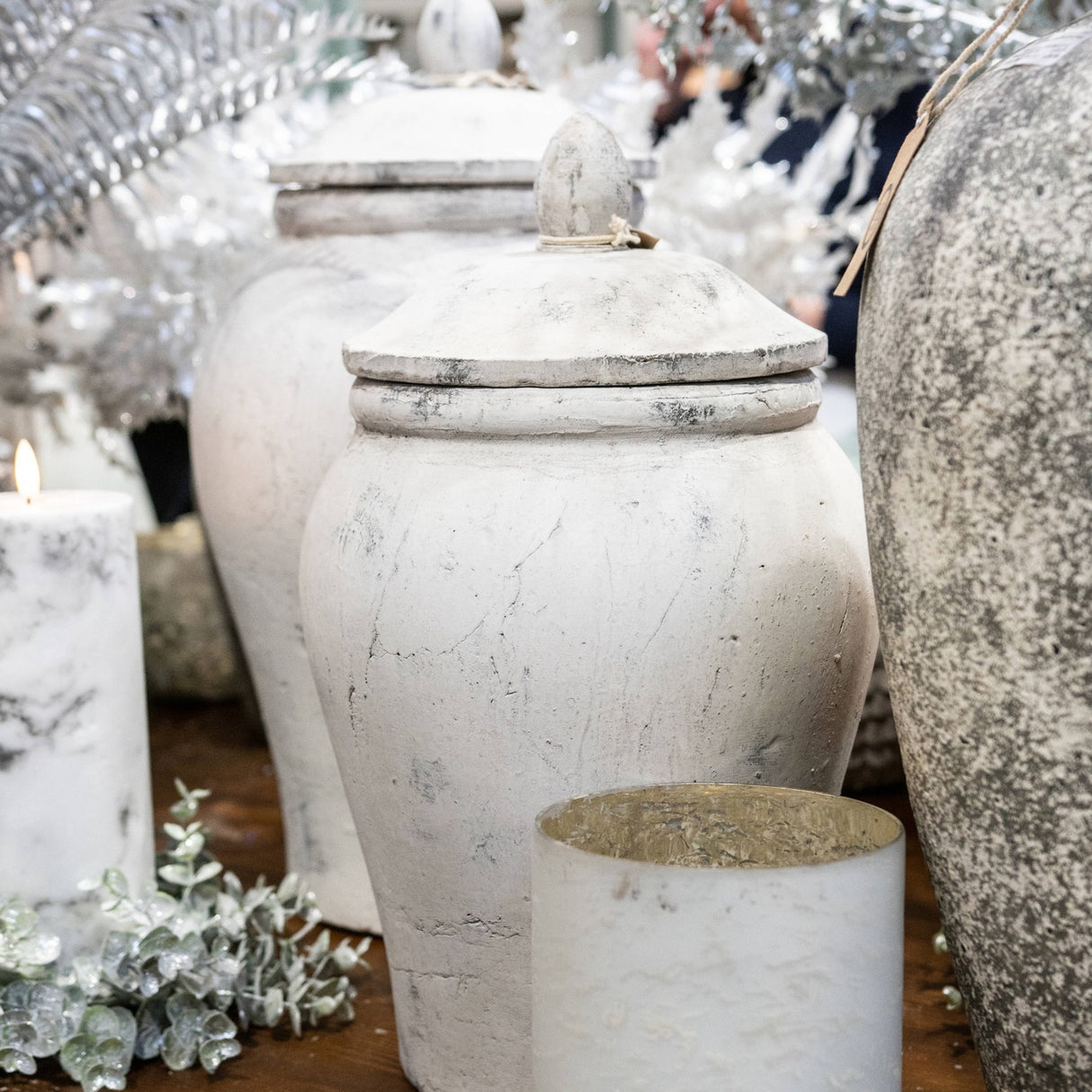 Hill Interiors large stone-effect ceramic ginger jar vase in beige with domed lid, styled among candles, silver foliage and a speckled grey vase.