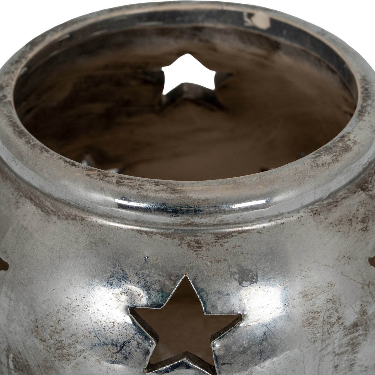 Close-up of Hill Interiors Small Star Tea Light Lantern in silver, showing the ceramic body's distressed metallic finish and pierced star cut-outs.