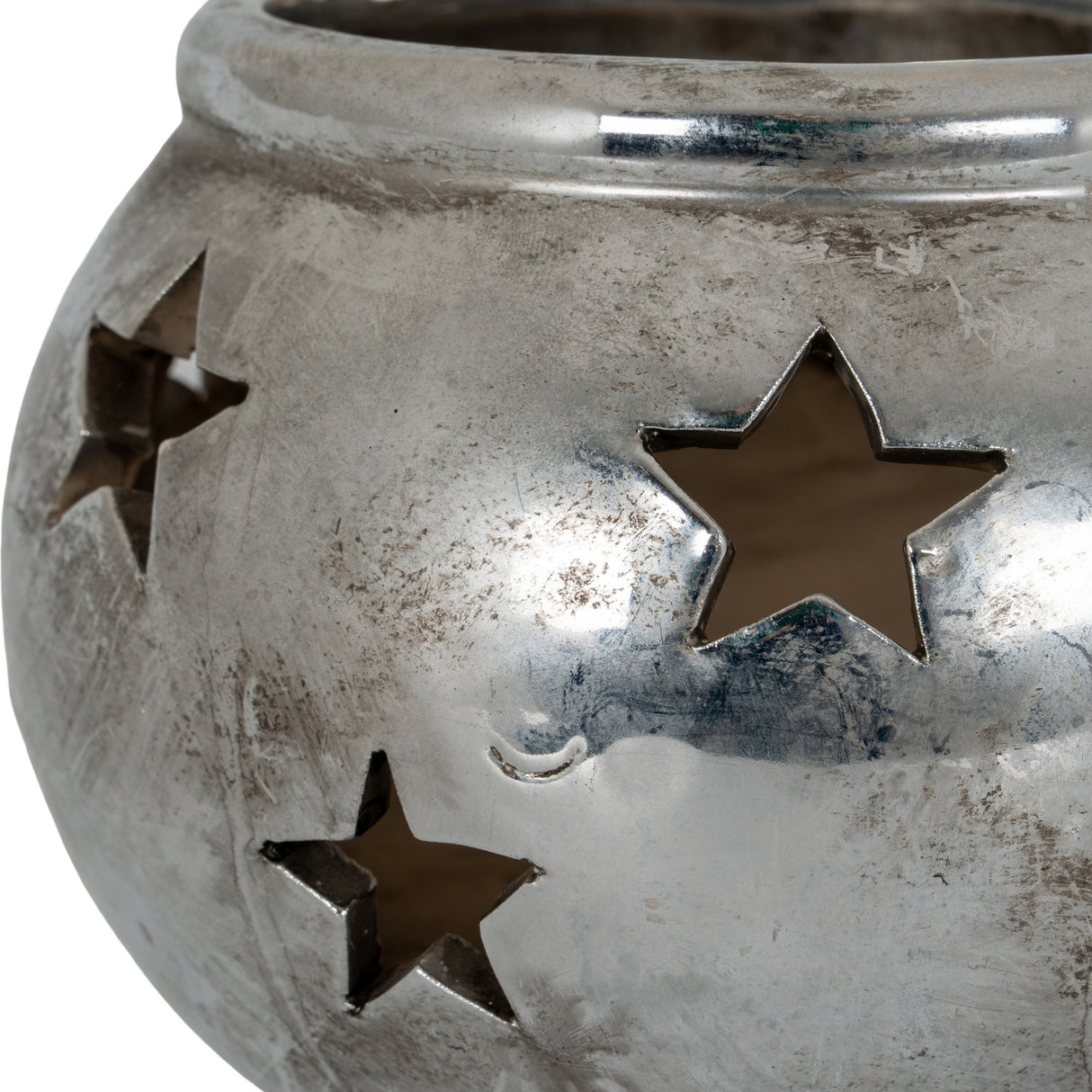 Close-up of the Hill Interiors Small Star Tea Light Lantern in silver, showing the ceramic body with pierced star cut-outs and a weathered metallic finish.