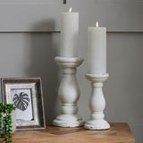 Hill Interiors Convex Matt Silver Photo Frame displayed upright on a wooden sideboard beside white candle holders with lit pillar candles and a trailing plant.