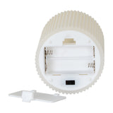 Underside of the Hill Interiors beige textured ribbed LED pillar candle showing the battery compartment, on/off switch and removable cover on white.