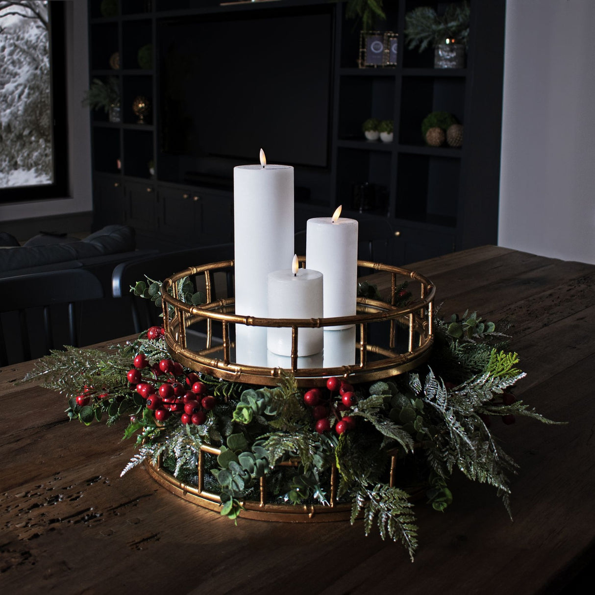 Hill Interiors Medium Faux Festive Berry Pick styled with white pillar candles in a gold bamboo-style tray centrepiece on a wooden dining table.
