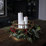 Hill Interiors Medium Faux Festive Berry Pick styled with white pillar candles in a gold bamboo-style tray centrepiece on a wooden dining table.