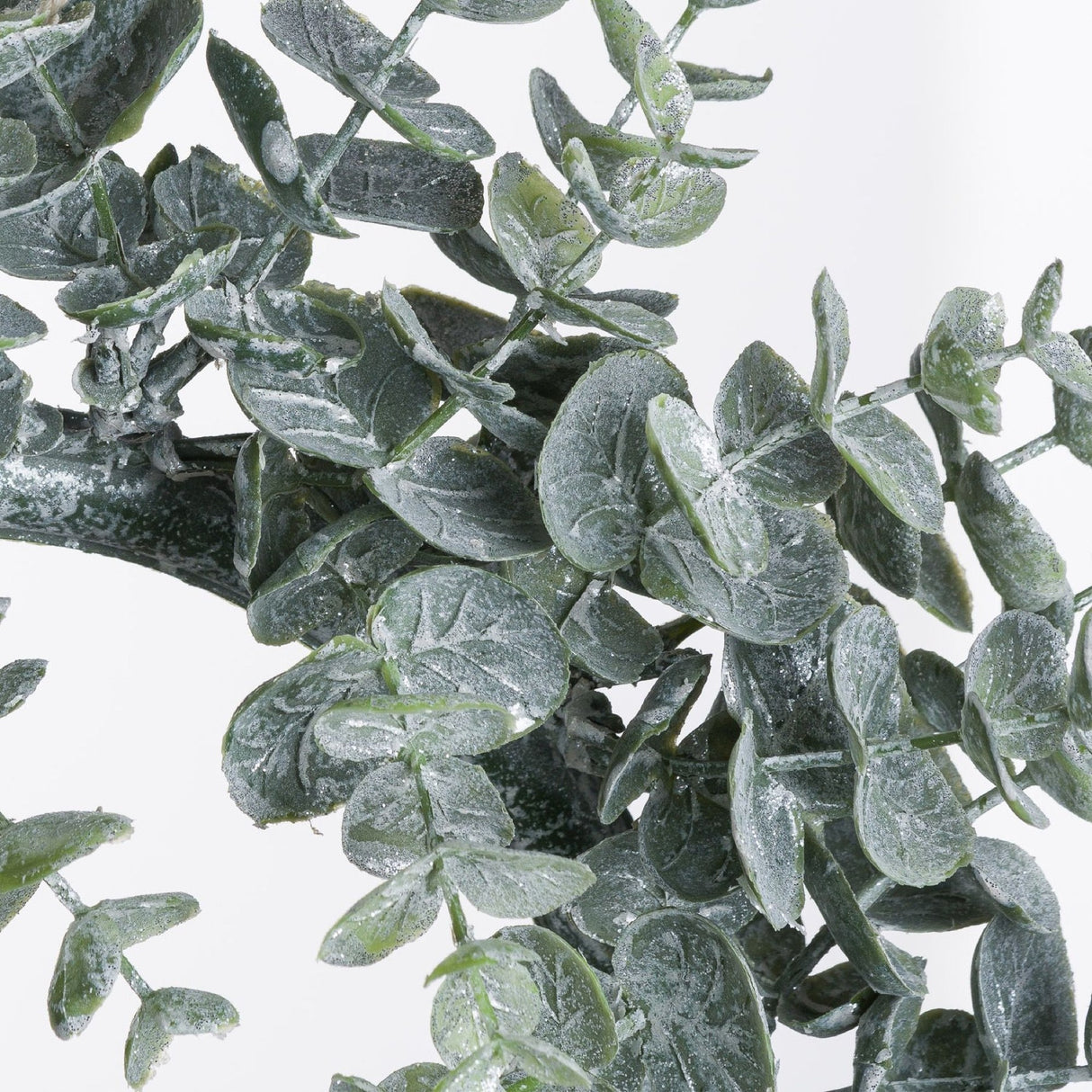Close-up of Hill Interiors Large Frosted Eucalyptus Candle Wreath in white, showing layered moulded plastic leaves with a powdery frosted finish.