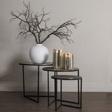 Hill Interiors Large Faux Branch Spray in a white round vase beside gold mercury glass candle holders on tiered black nesting tables.