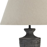 Close-up of the Hill Interiors Ondelle Urn Wooden Table Lamp in brown, showing the turned timber base with visible grain and a neutral tapered linen shade.