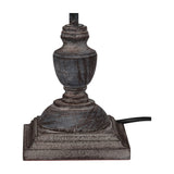 Hill Interiors Ondelle Stem Table Lamp base in distressed brown metal with turned urn-shaped stem on a stepped square plinth, shown on white.