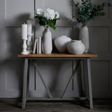 Hill Interiors Large Tall Ceramic Vase in beige with white hydrangeas, styled on a wooden console with candles, books and grouped vases.
