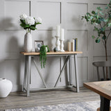Hill Interiors tall beige ceramic vase with white hydrangeas styled on a wooden console table beside candles and decor against a grey panelled wall.