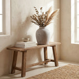 Hill Interiors Stone-Effect Ceramic Vase in beige with rounded form holding dried eucalyptus and pampas grass on a rustic wooden bench beside stacked books.
