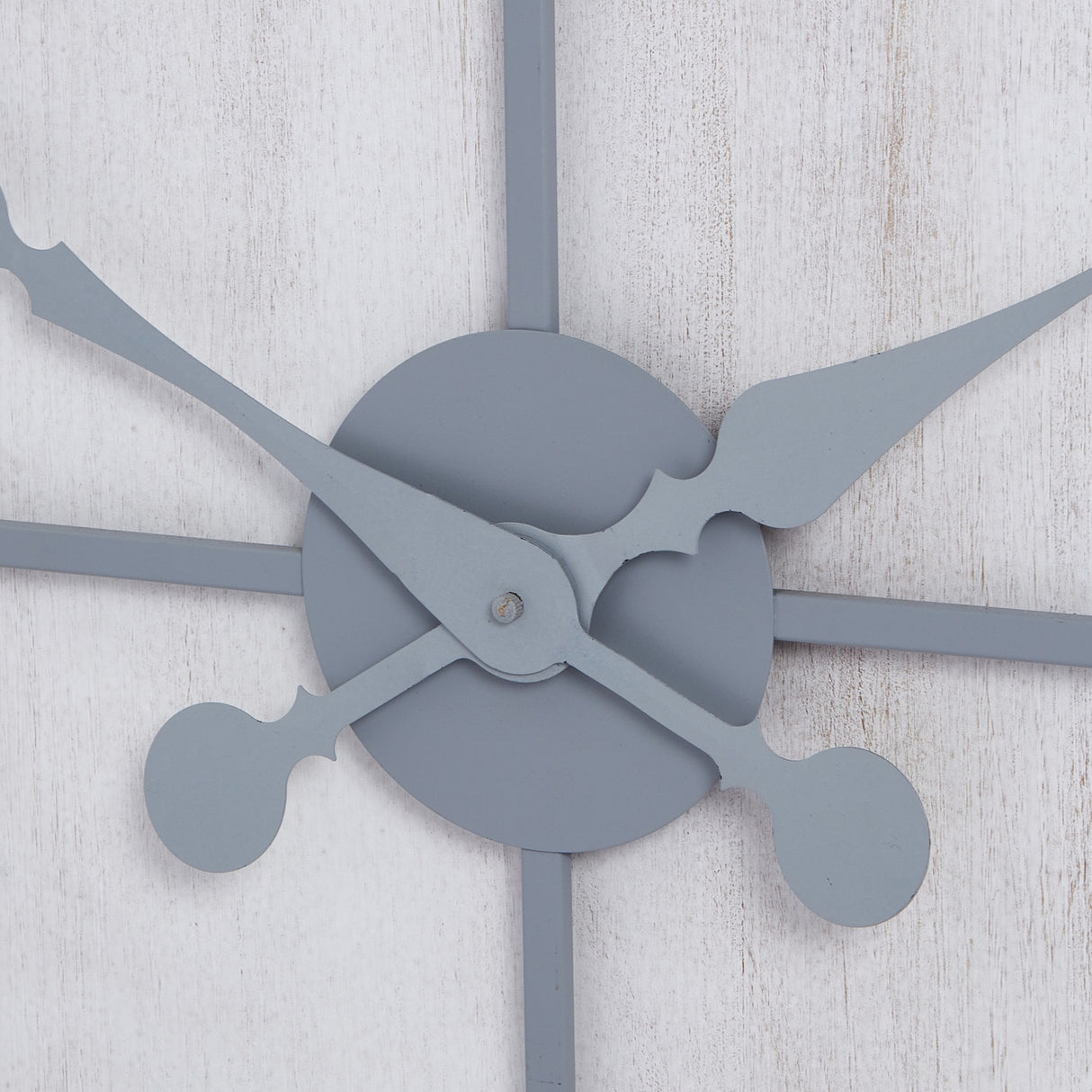 Close-up of Hill Interiors Panelled Metal Wall Clock in silver, showing the central hub with ornate hour and minute hands against a whitewashed panelled face.
