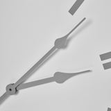 Close-up of Hill Interiors White Round Metal Wall Clock showing slim grey hands and rectangular hour markers on a crisp white dial.