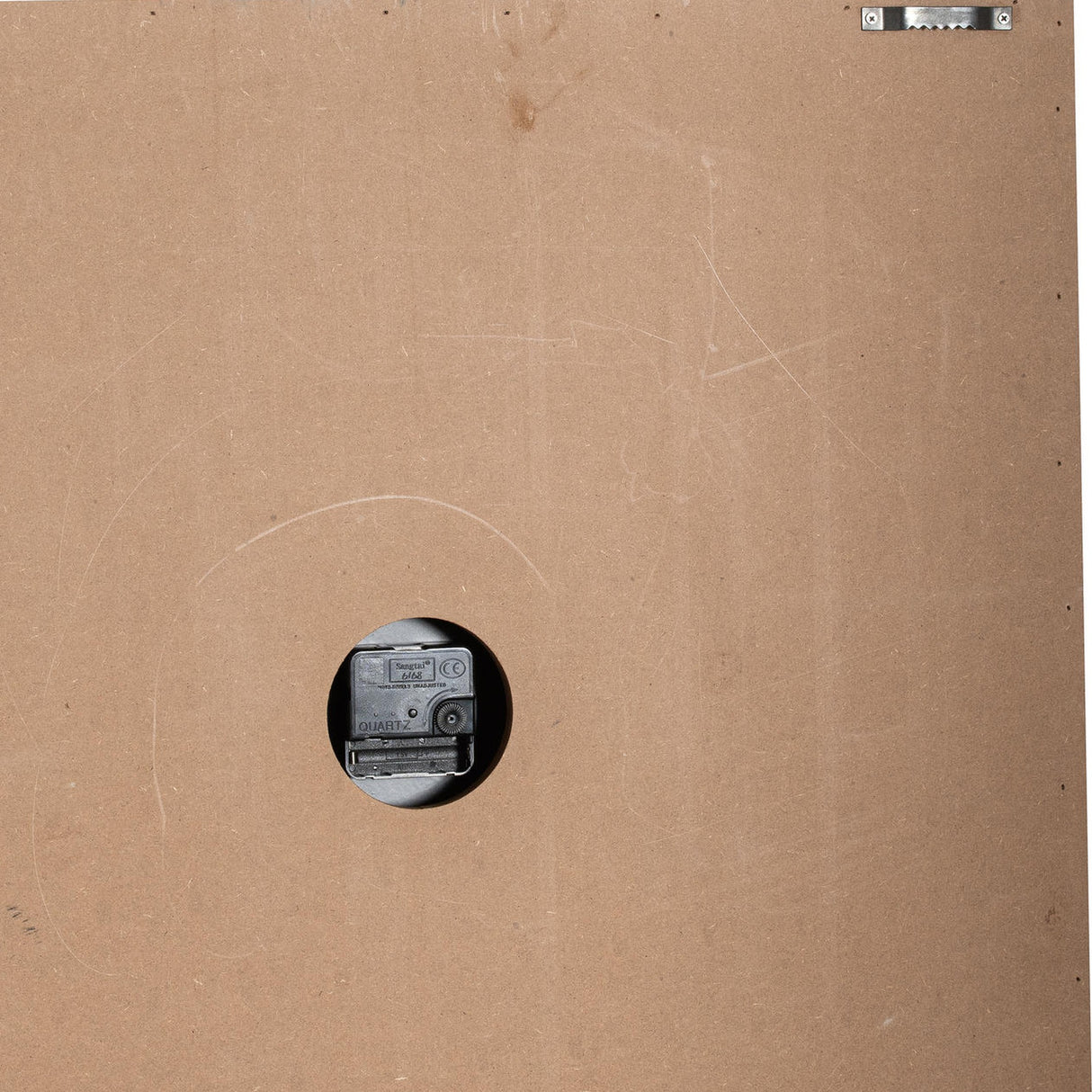 Reverse of Hill Interiors square wooden wall clock showing brown backing board, central quartz movement and metal hanging bracket at the top corner.