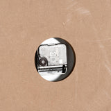 Close-up of the quartz movement on the back of the Hill Interiors Large Square Wooden Wall Clock, showing the AA battery slot and adjustment dial.