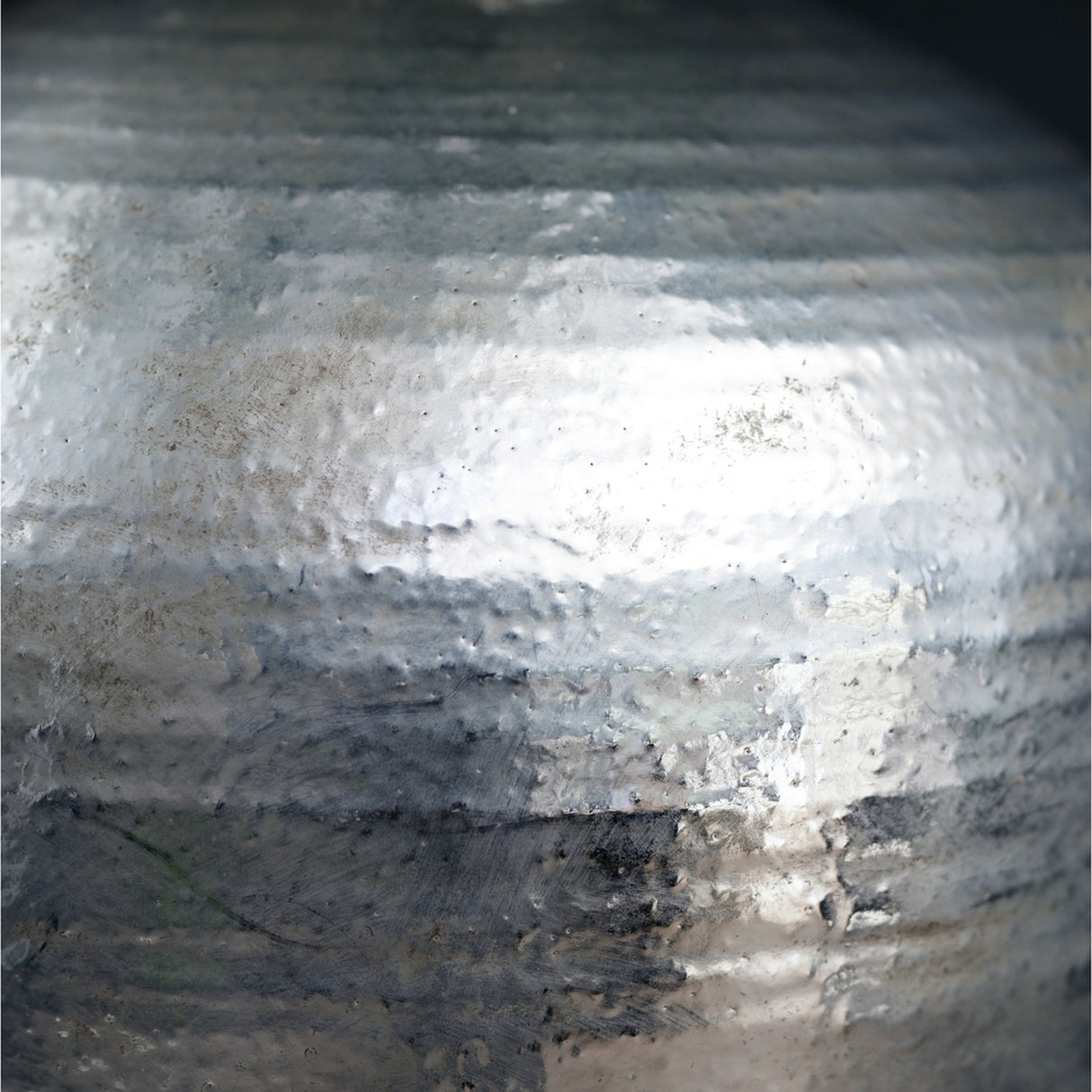 Close-up of the Hill Interiors Silver Astral Vase showing the rounded ceramic body and reflective silver glaze with a softly textured, light-catching finish.