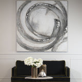 Hill Interiors hand painted galaxy canvas wall art in silver, grey and charcoal swirls, hung above a black sofa with white hydrangeas in a living room.