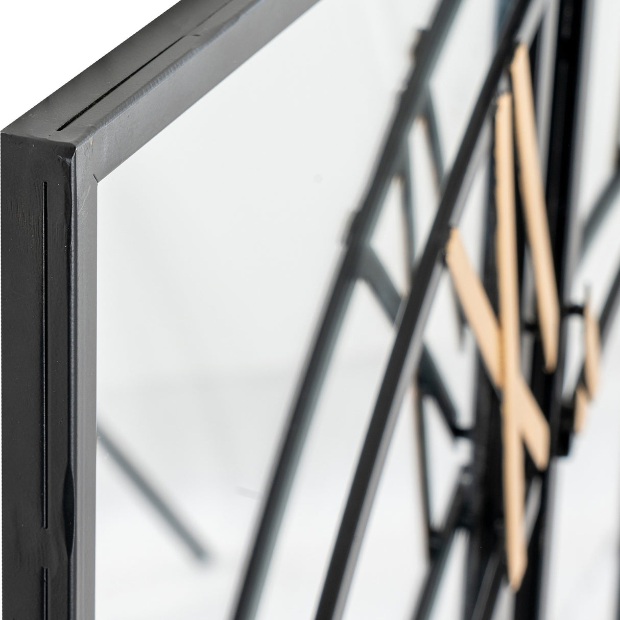 Close-up of the Hill Interiors Black and Gold Round Wall Clock 113cm showing the slim black metal frame, glass face and gold Roman numerals.