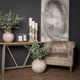 Hill Interiors Stone Ceramic Vase in beige with a rounded textured body, styled with eucalyptus stems beside a console table and velvet armchair.