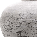 Close-up of the Hill Interiors Stone Ceramic Vase in beige, showing the rounded body with a chalky, weathered matt glaze and dark tonal speckling.