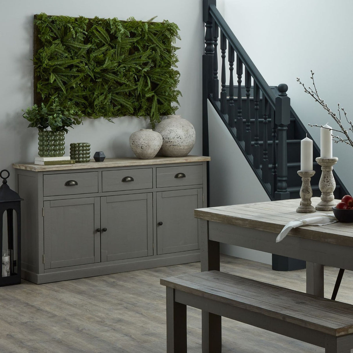 Hill Interiors Stone Ceramic Vases in beige with rounded stone-look forms on a wooden sideboard, styled with ferns, greenery and a dark staircase behind.