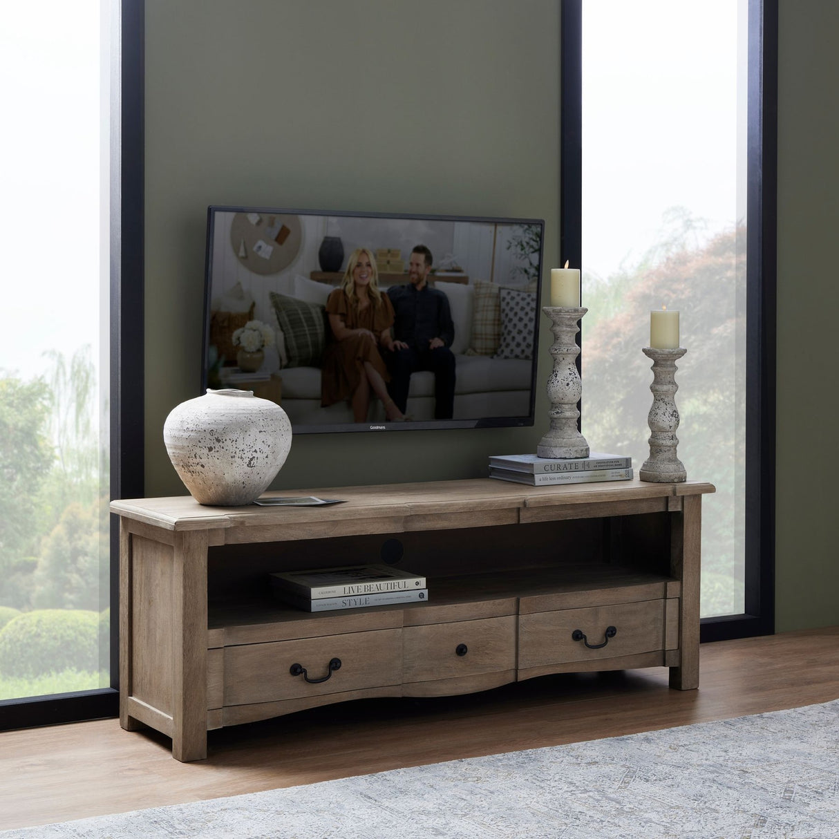 Hill Interiors Stone Ceramic Vase in beige with a rounded urn shape, styled on a wooden TV unit beside candles, books and a mounted television.